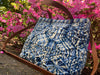 Max Sky Macrame Tote blue and cream tote bag with a leather crossbody strap and leather handle next to flowers