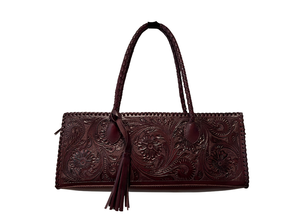 Brown leather handbag with intricate patterns on a white background