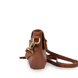 Small leather crossbody bag with a brass ring on the front handle up, side view, Sabrina Crossbody Bag.