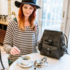  woman drinking tea with a leather backpack on the table, Sadie Leather Backpack,.