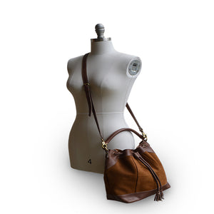 Mannequin wearing brown suede bucket bag, Rowan Suede Crossbody Bag.