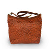 front view of Rust leather shoulder bag with handle up, quilted floral detail, quilted Cari Quilted Shoulder Bag.